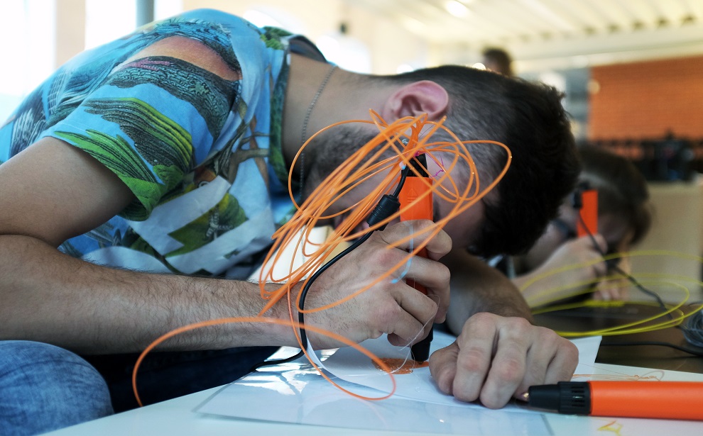 Powiększ obraz: Jeden z uczestników oprowadzania sprawdza możliwości długopisów 3D
