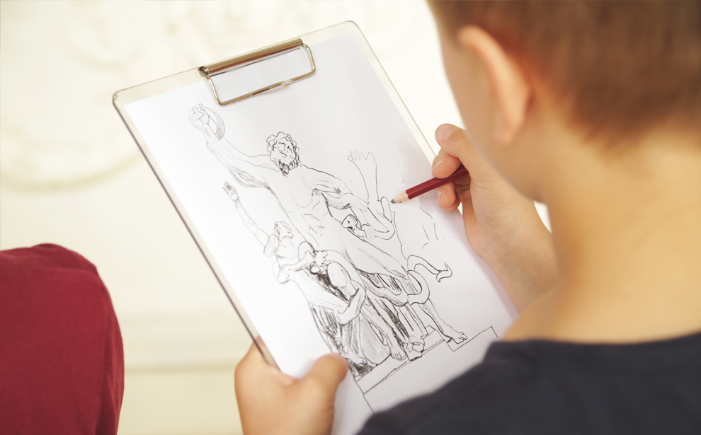 Powiększ obraz: Zdjęcie przedstawia chłopca szkicującego wizerunek rzeźby